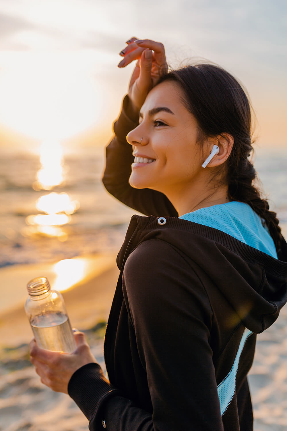 attractive-slim-woman-doing-sport-exercises-morning-sunrise-beach-sports-wear-thirsty-drinking-water-bottle-healthy-lifestyle-listening-music-wireless-earphones-hot-summer-day (1)